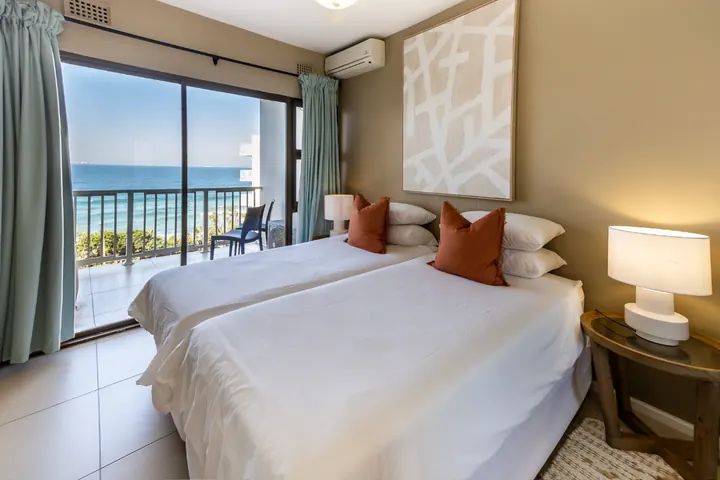 Second bedroom with twin beds and doors onto the beachfront balcony