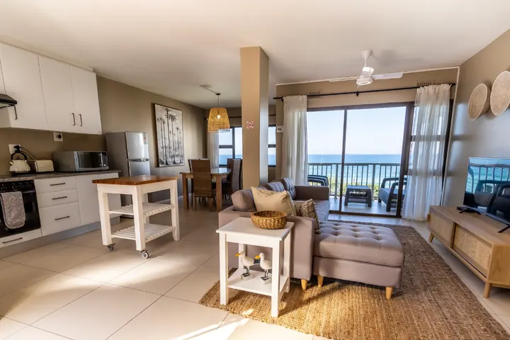 Open-plan kitchen and lounge opening onto the sea-view balcony