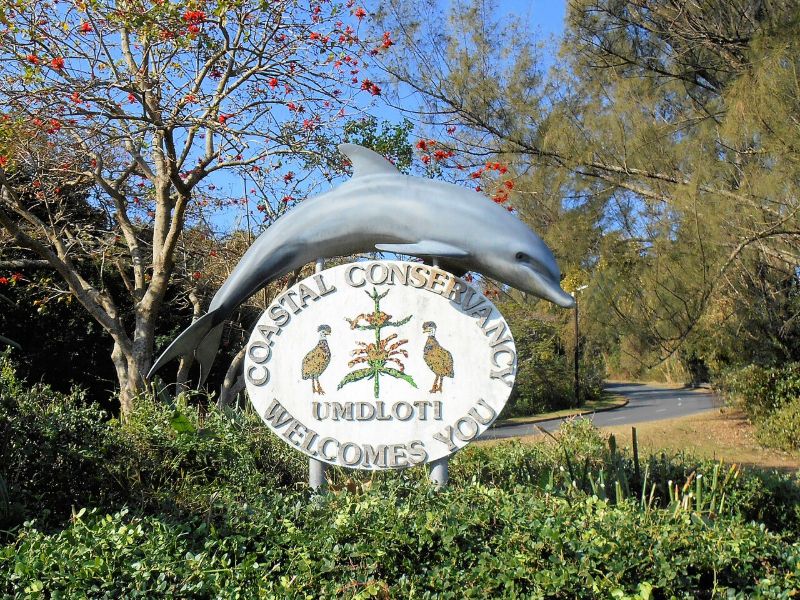 The dolphin sign of the Umdloti Coastal Conservancy at the village entrance